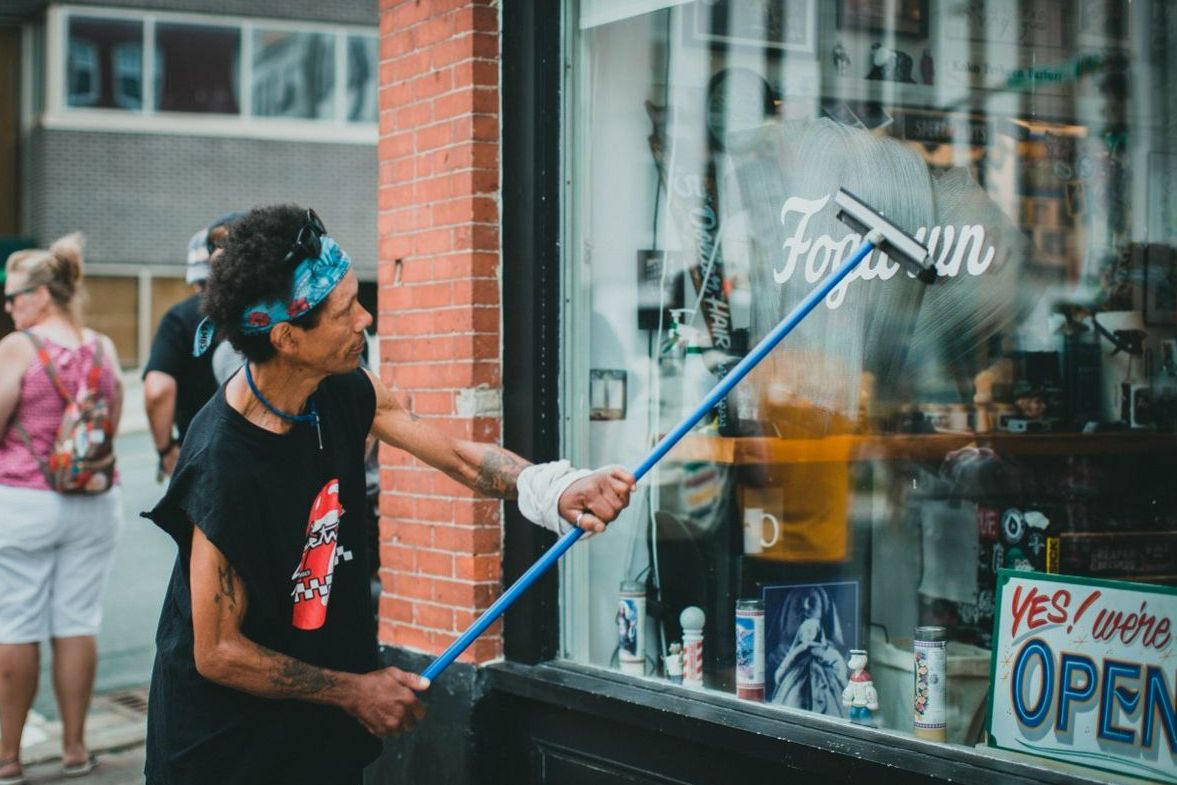 Window cleaner washing glass with a squeegee